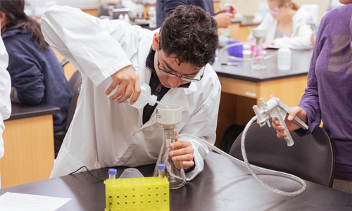 YVC student measures out a liquid during biology class.