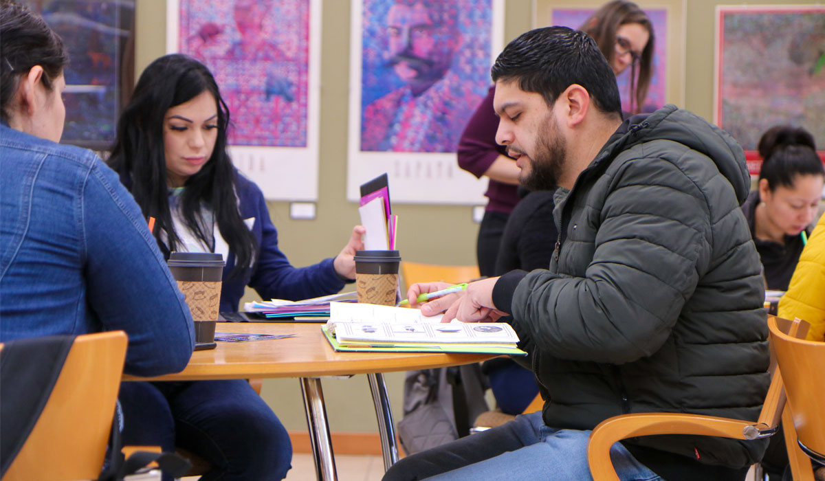 Student writes in his notebook during class. 