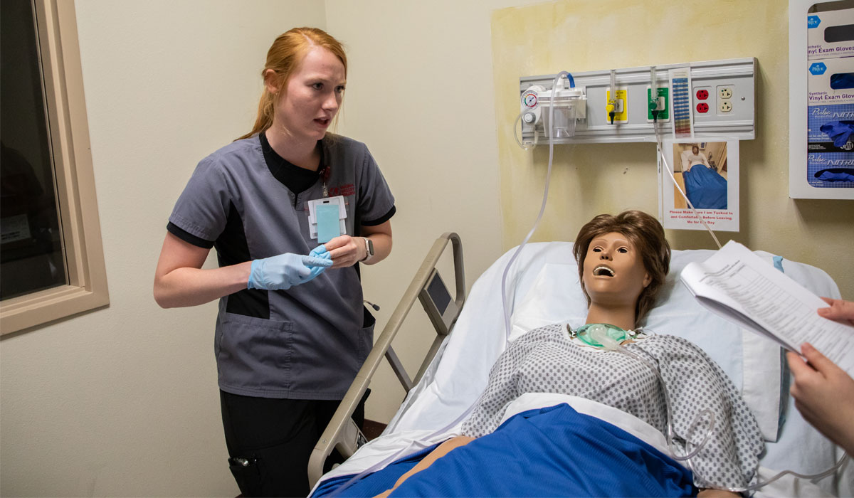 yvc nursing student removing gloves after working with a test patient during class. 