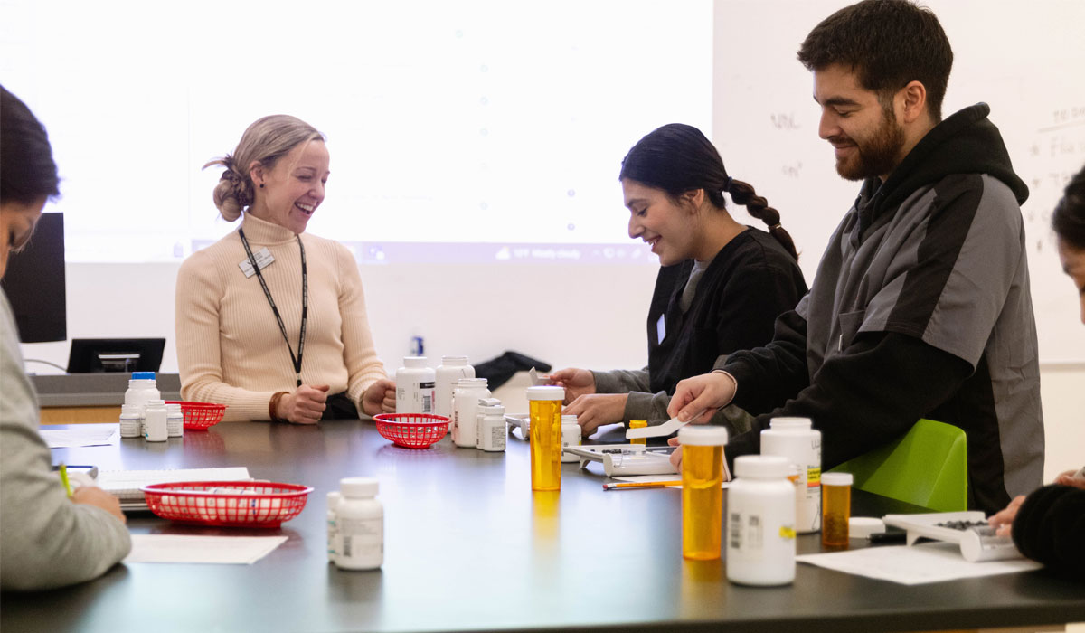 YVC Pharmacy Instructor works with students during a pharmacutical drug exercise. 