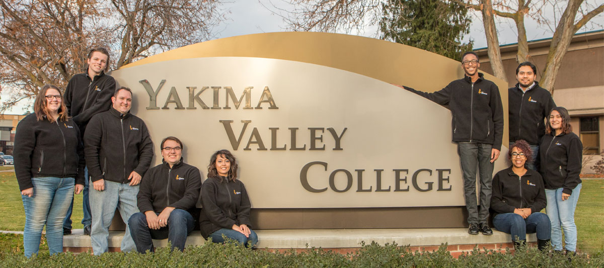 YVC music students pose in front of YVC sign on campus. 