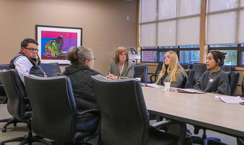 Students and legislators meeting around a conference table