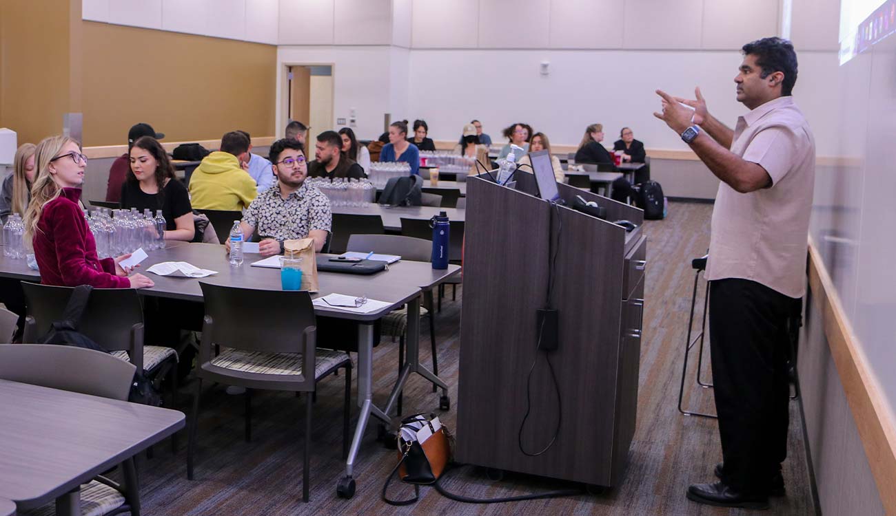 Instructor talks to students in business class