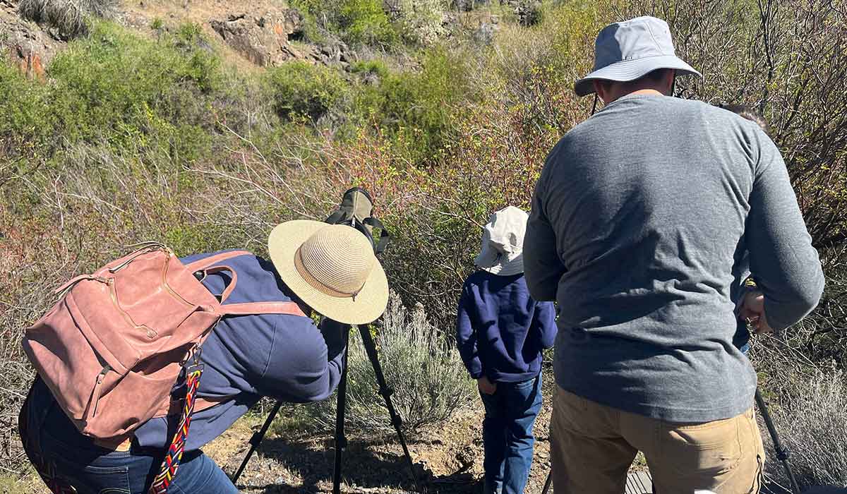 Visitors look through telescopes during Earth Day