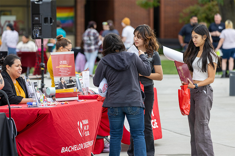 Yakima Valley College students talk to staff member at Yak Family Night