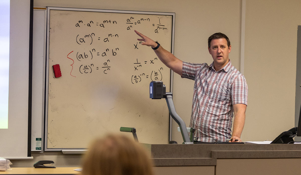 YVC professor teaching math on a white board. 