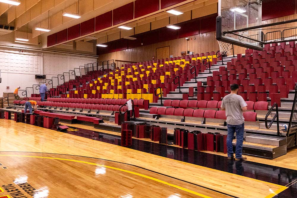 Workers install bleachers in Sherar Gymnaisum