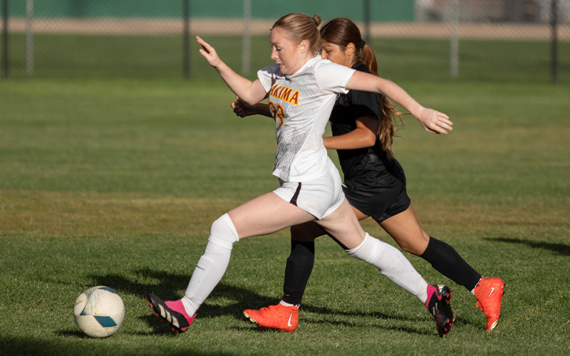 Yakima Valley College women's soccer player running with ball