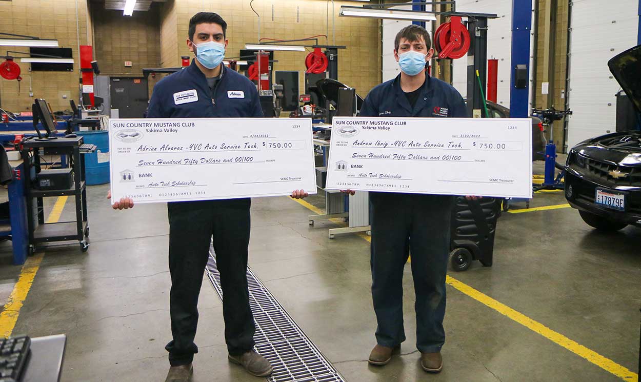 Students holding large checks