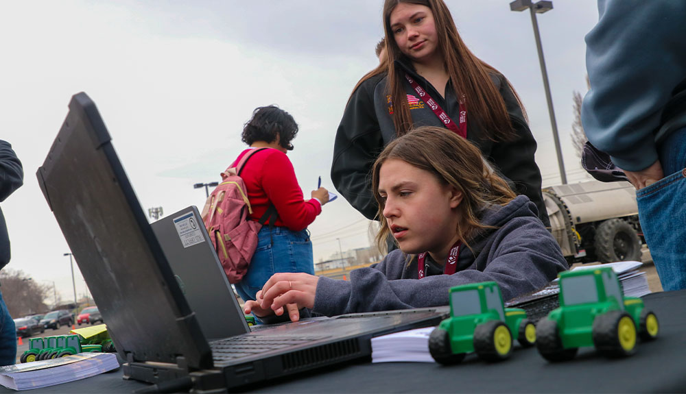 Female high school student types on laptop computer