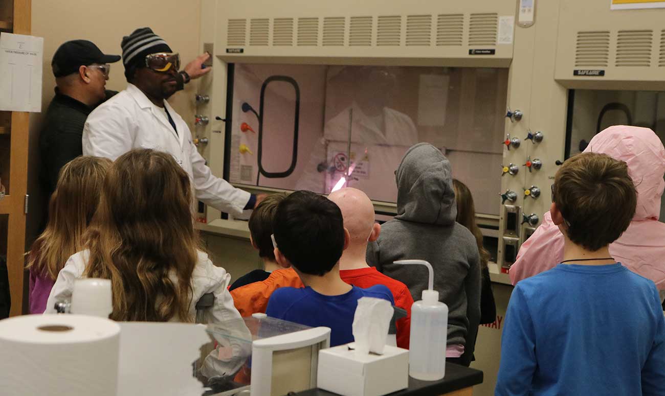 Children watching YVC rep give Chem demo. 