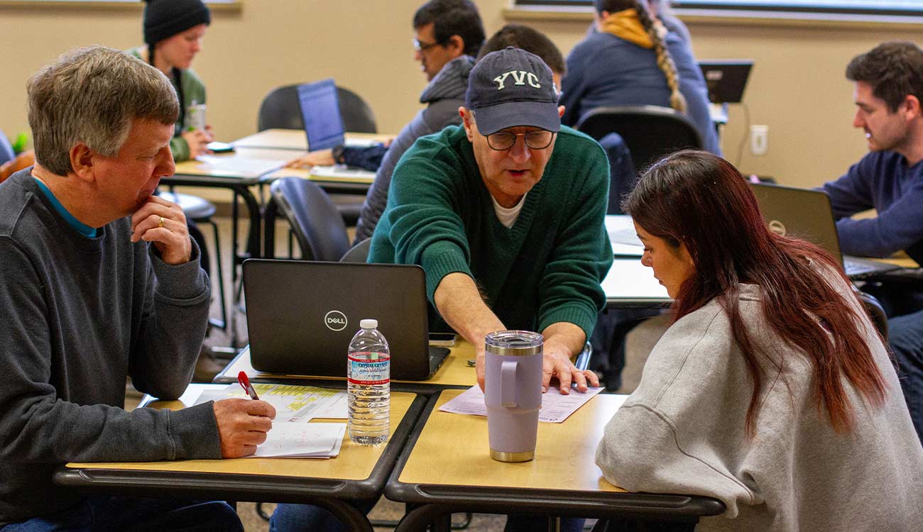 Instructor talks to student at table