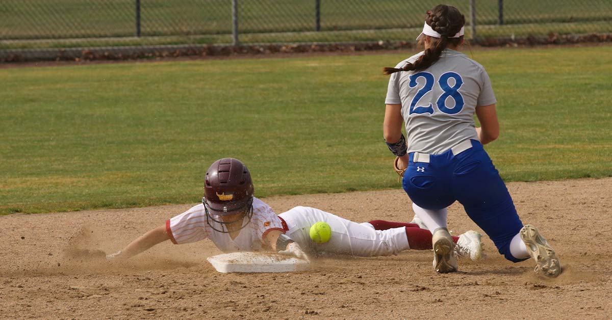 Softball player slides into second base