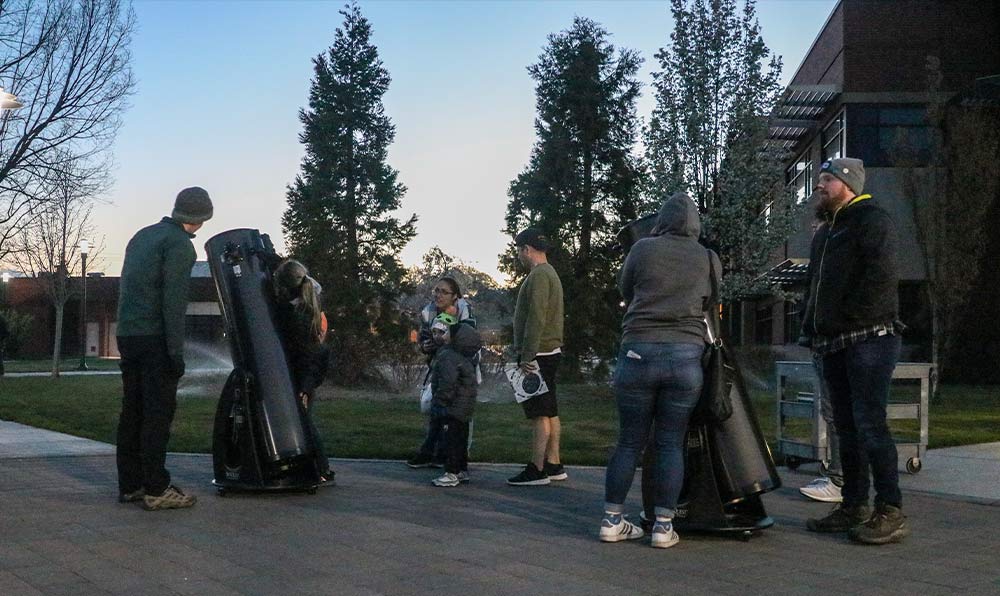 People view stars through telescopes