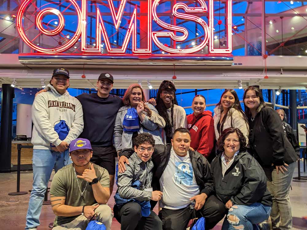 Students post in front of OMSI sign