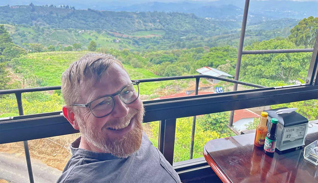 Man sits on patio over looking vista in Costa Rica.