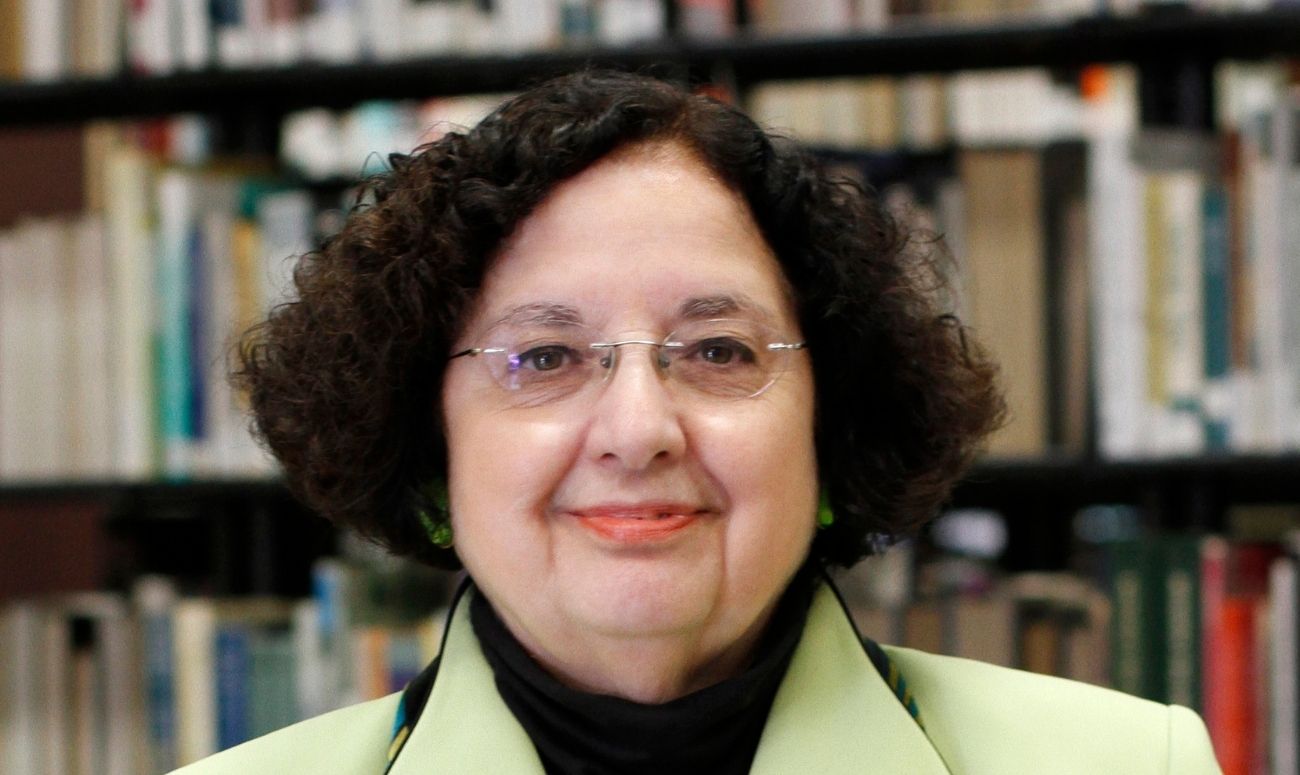 YVC President Linda Kaminski poses for picture with books in the background. 