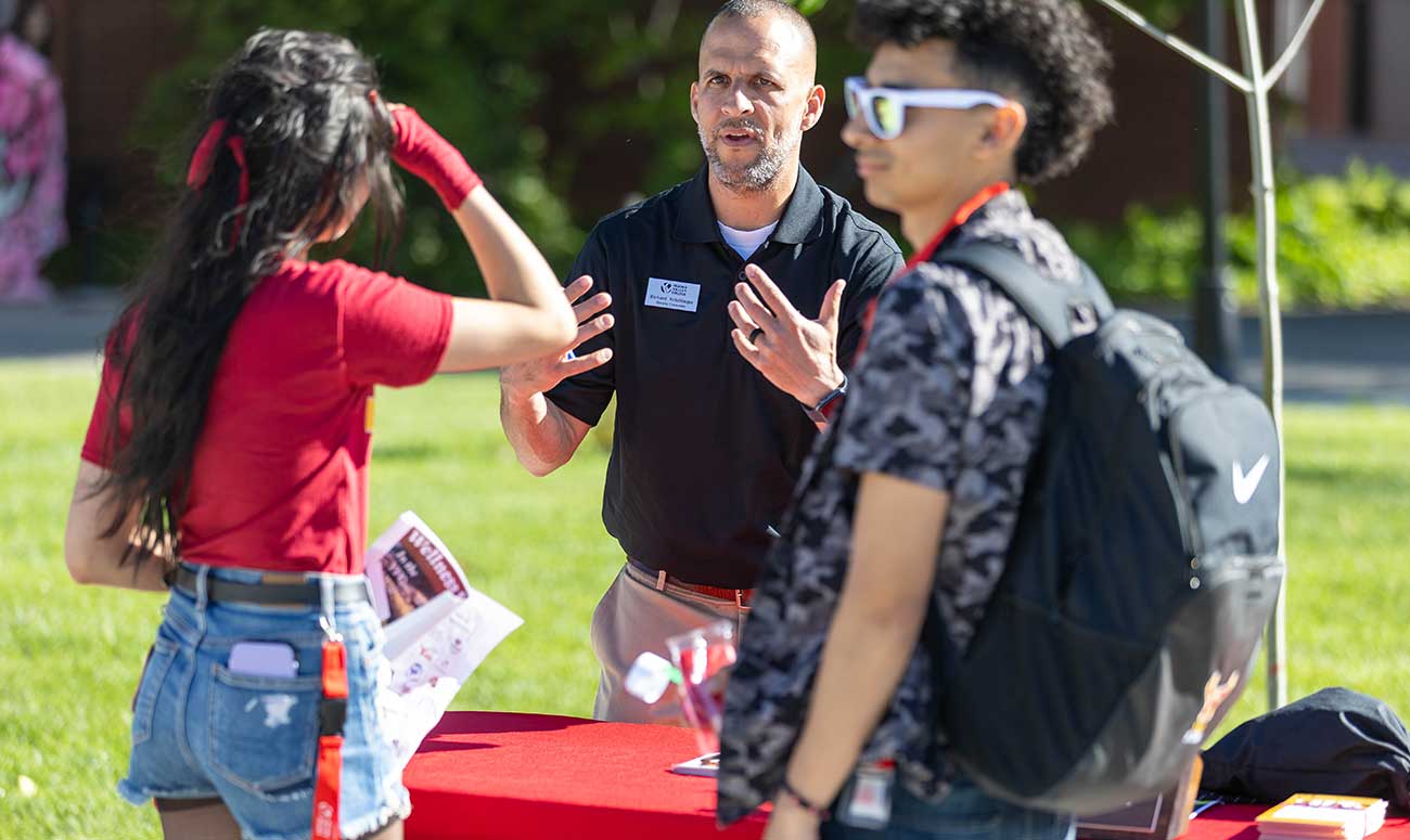 YVC Staff member speaks to students outside on the YVC campus during Yak Night. 