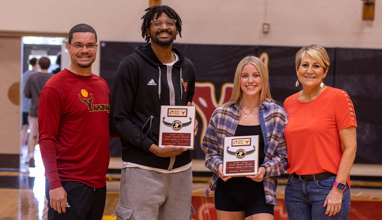 Two YVC athletes pose for picture holding their award placques. 