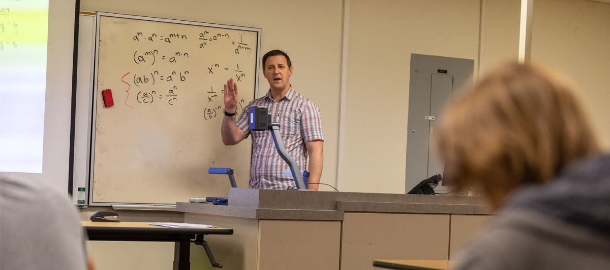 YVC professor working on white board during a lecture.