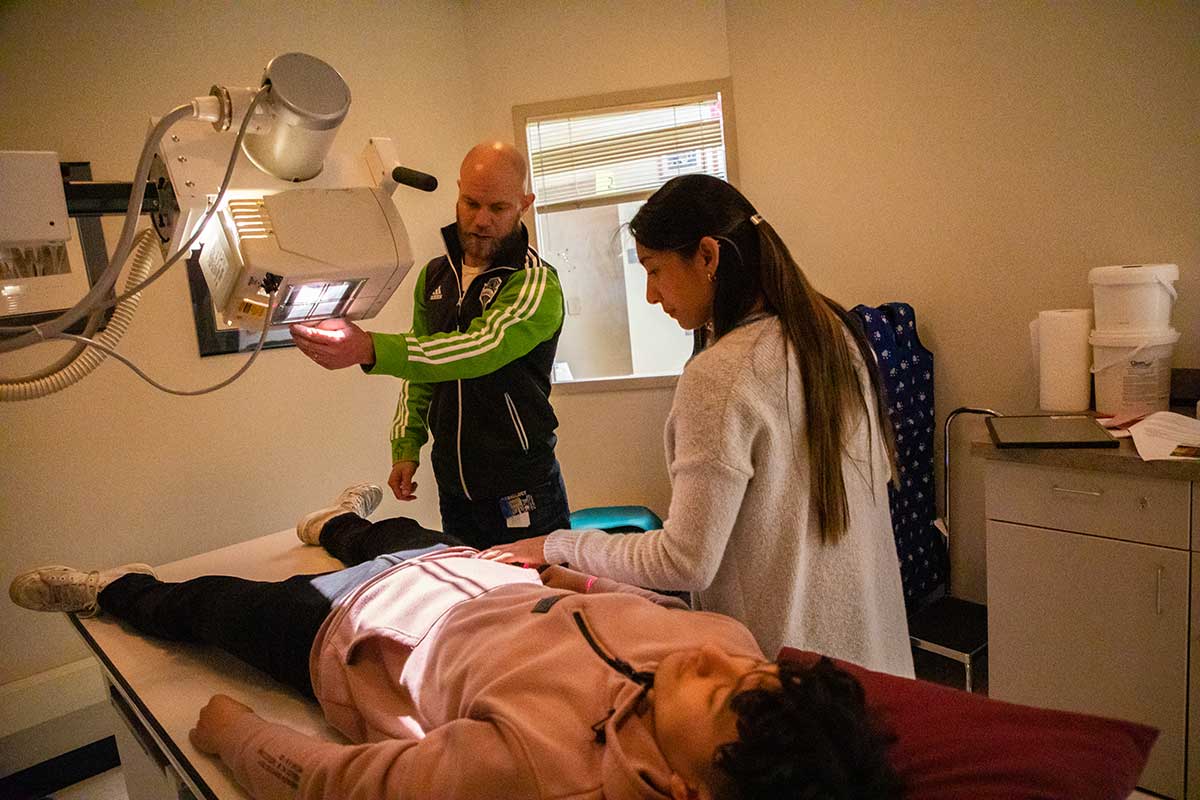 A radiologic science student does a chest xray while the instructor oversees