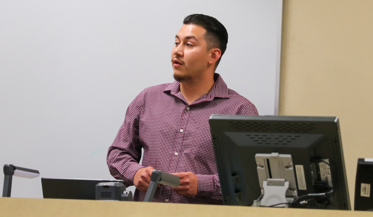 Man speaks to room of people in a YVC classroom. 