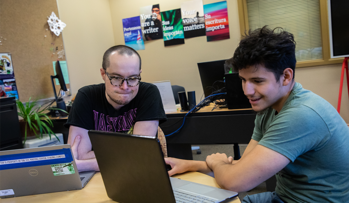 Student works with tutor on his lap top in the YVC Writing Center