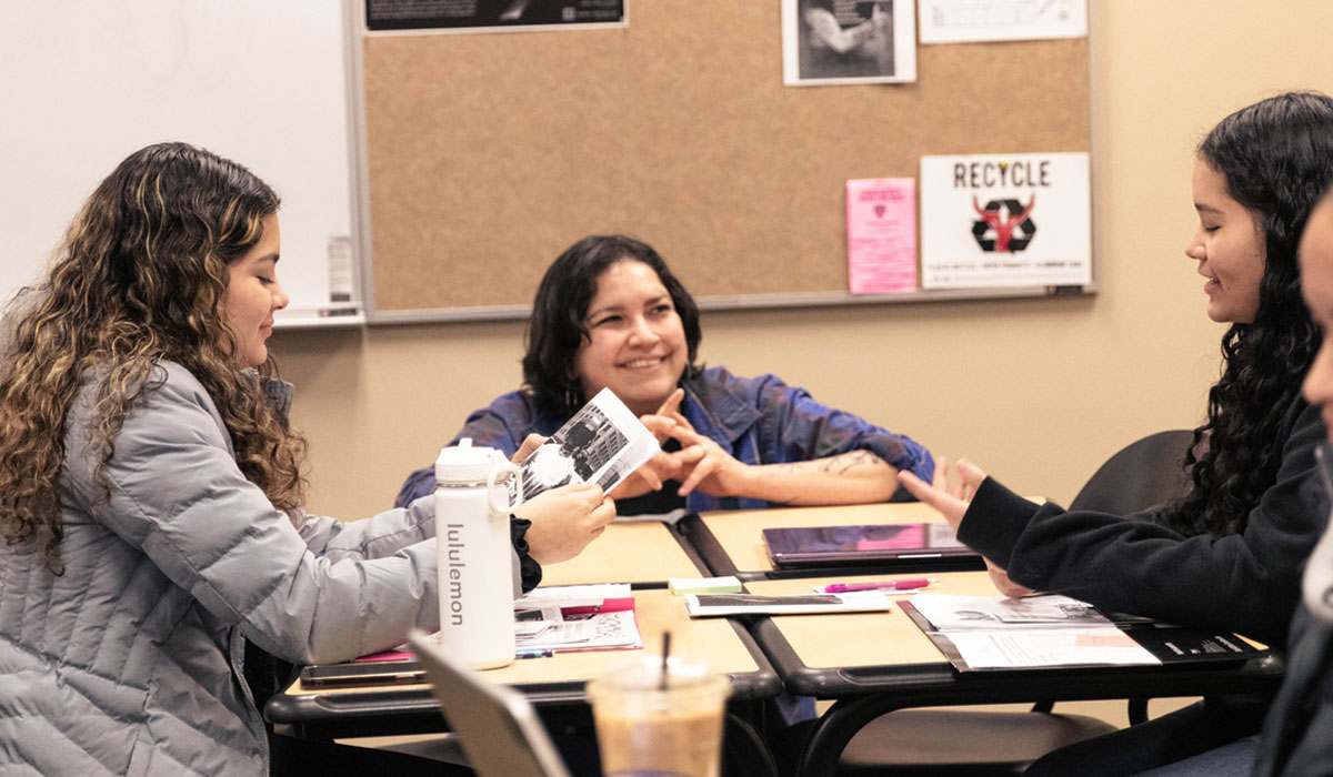 Staff Member speaking to group of students during class.