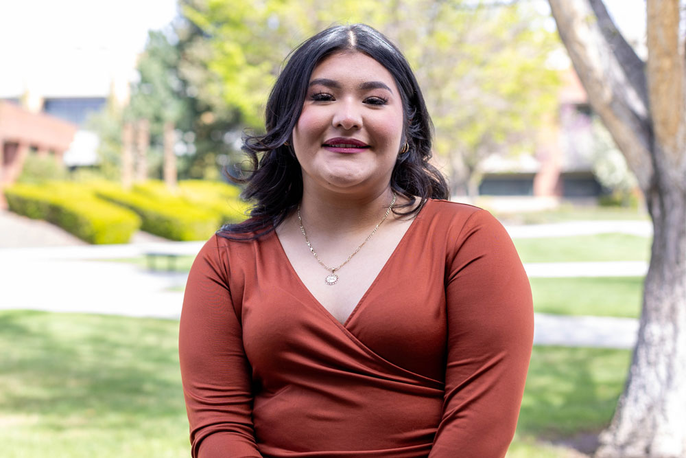 Guadalupe Torres poses for picture with YVC Campus in the background. 