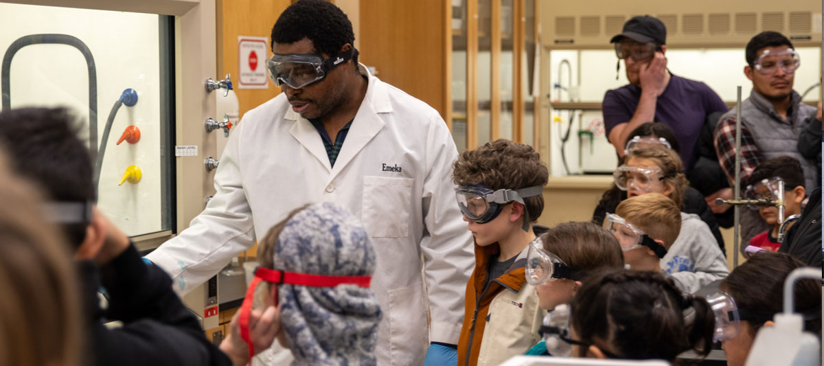 YVC representative demonstrates a science experiment on a YVC lab. 