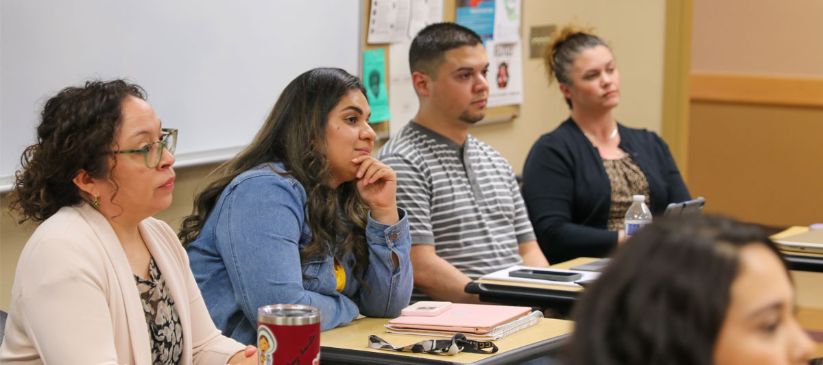 Four YVC Students sitting at desks and listening in during a class. 