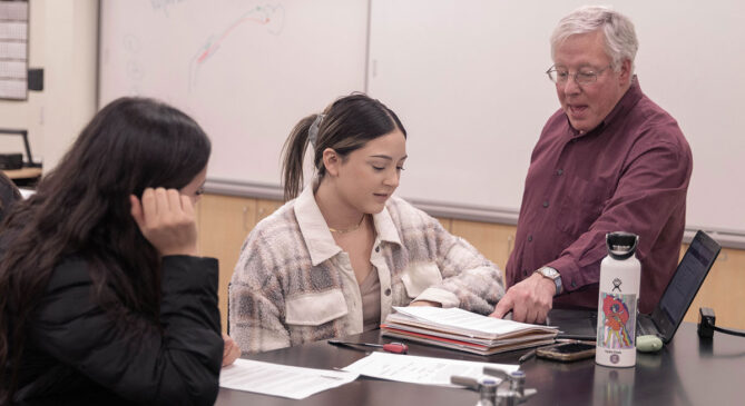 Students talk with instructor in class
